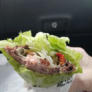 a hand holding a sandwich
