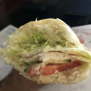 a sandwich with lettuce and tomatoes