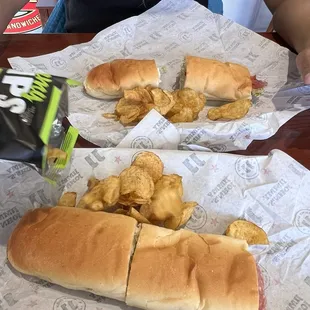 two sub sandwiches with potato chips