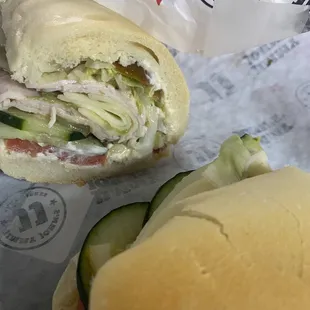 a turkey sandwich and a cucumber