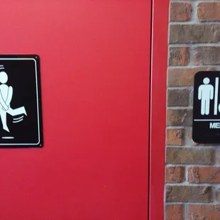 a restroom door with a toilet and men&apos;s restroom sign