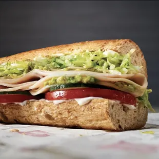 a turkey sandwich with lettuce and tomato