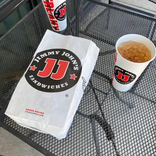 a drink and a paper bag on a table