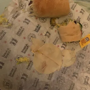 a half eaten sandwich on a wrapper
