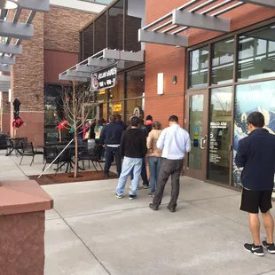 a group of people standing outside of a restaurant