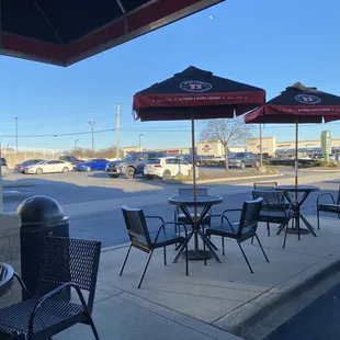 tables and umbrellas on the sidewalk