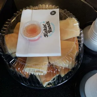 a tray of hot dogs and a cup of ketchup