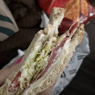 a person holding a sandwich