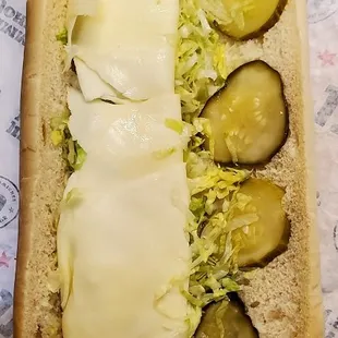 a hot dog with pickles and cheese