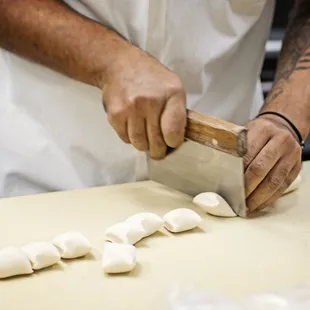 a chef using a knife to cut dough
