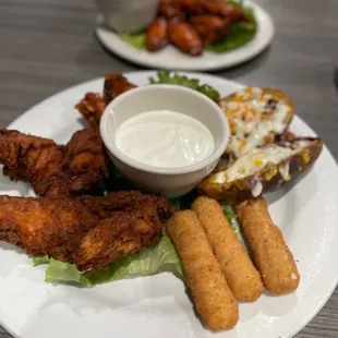 a plate of fried chicken and a bowl of ranch dressing