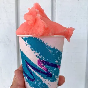 a hand holding a cup of watermelon