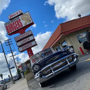 a classic car parked in front of a diner