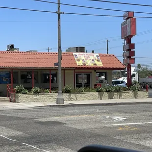 Exterior from across the street, parking to the right.