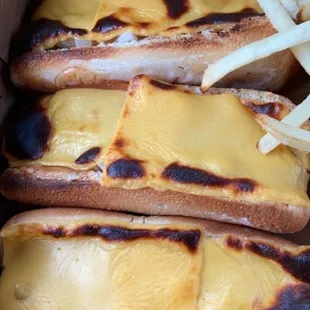 Dogs with cheese, sauce, pickles, and onions
