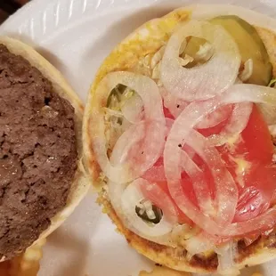a hamburger with onions and tomatoes