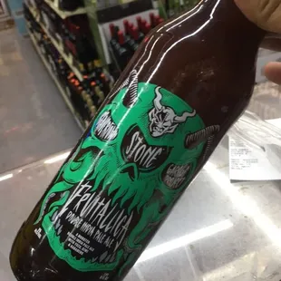 a hand holding a bottle of beer