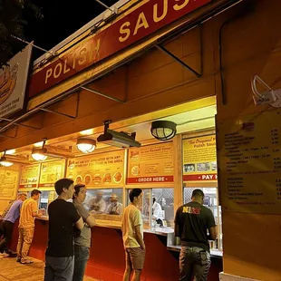 a group of people standing outside of a restaurant