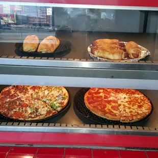 Hot and ready Pizza by the Slice, Pig in the Blankets and Calzones.