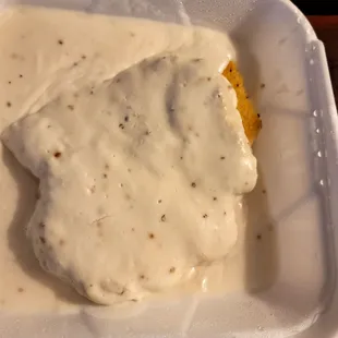 Country Fried steak with gravy amd biscuits underneath