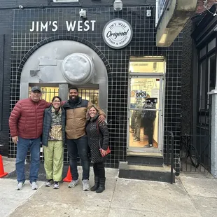 three people standing in front of a restaurant