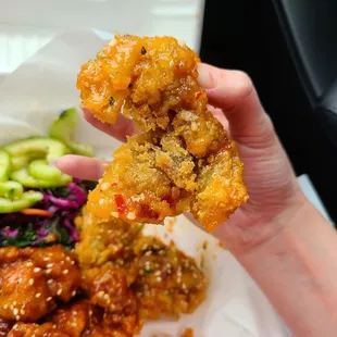 a hand holding a piece of fried food