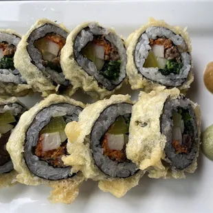 a plate of sushi rolls on a white plate