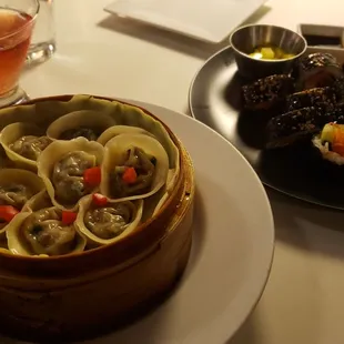 a bowl of dumplings and a plate of food