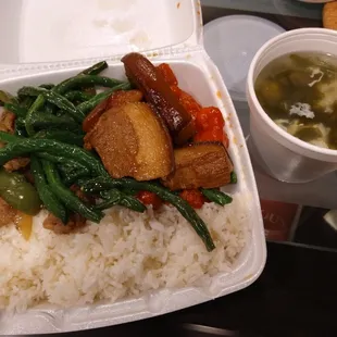 a take out container with rice and vegetables