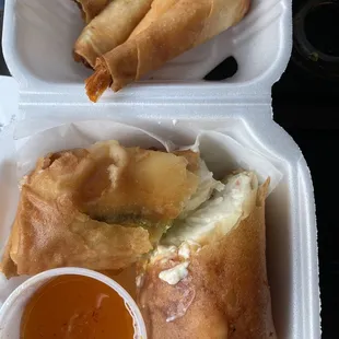 two takeout containers with food in them