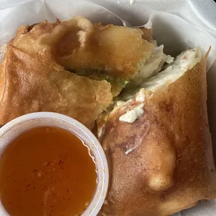 a close up of a sandwich with a side of dipping sauce