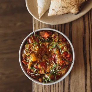a bowl of chili and pita bread