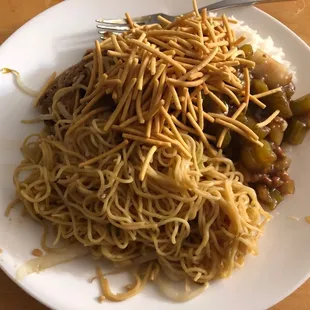 a plate of noodles and meat