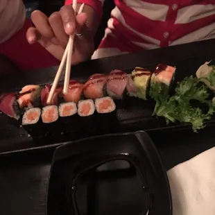 a person eating sushi with chopsticks