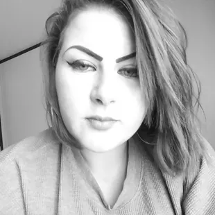 a woman with long, wavy hair and eyeliners