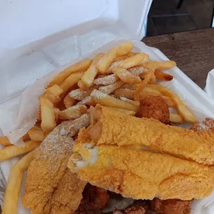 Fried catfish fillet, fried  french fries  and white bread  .