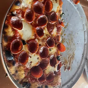 a half eaten pepperoni pizza