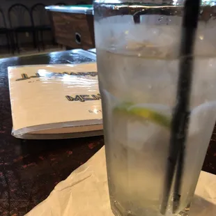 a glass of water with ice and a slice of lime