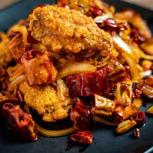 a pile of fried food on a black plate