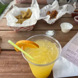 a glass of orange juice on a picnic table