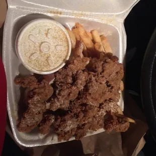 chicken and fries in a styrofoam container