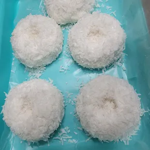 six coconut donuts on a blue tray