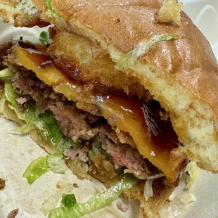 11.07.24 Western Bacon Cheeseburger (x-section) - 1/4-lb beef, bacon, cheddar cheese, onion rings, BBQ sauce on brioche bun