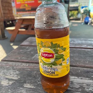 a bottle of lemonade on a picnic table