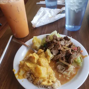 Chicken yellow curry, fried rice, spicy basil beef and steamed vegetables with a Thai tea.