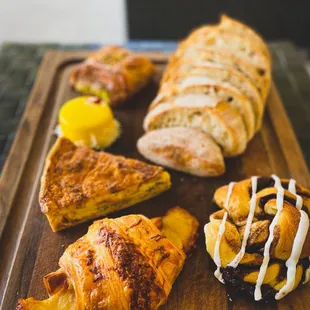 Chocolate babka, ham and cheese croissant, sourdough loaf, quiche Lorraine, raspberry mango cake, chocolate pistachio croissant
