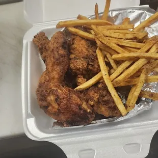 chicken and french fries in a styrofoam container