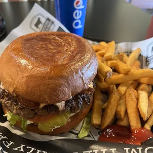 Angus beef burger with avocados and bacon, fresh baked buns, and fries