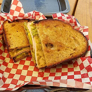 Smoked turkey, house cured and smoked bacon, and guacamole sandwich