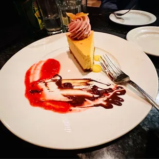 a slice of cheesecake with strawberries and sauce